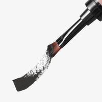 Makeup brush with black powder on a white background