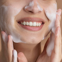 Person applying a foamy skincare product to their face